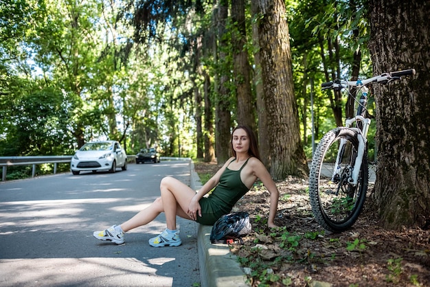 Happy young girl rides a bicycle in the forest on hot summer day Lifestyle