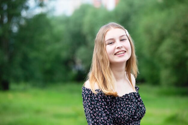 Ragazza felice in un vestito romantico su un prato verde di estate