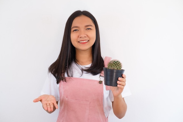 笑顔と白い背景の上のサボテンを示す幸せな少女