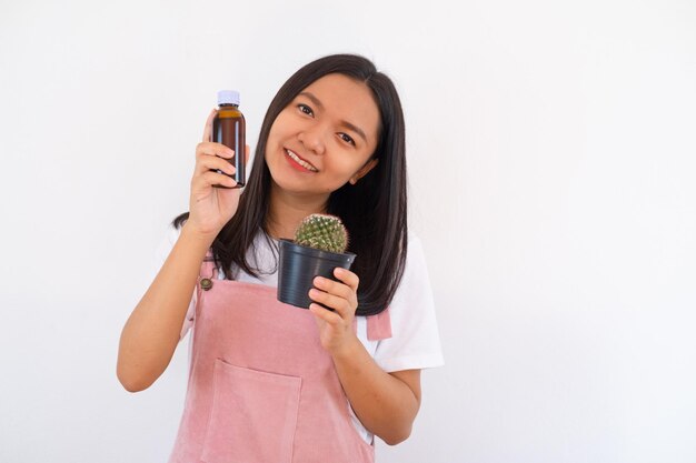 Happy young girl smiling and showing cactus on white background