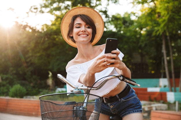 Happy young girl in summer clothes riding bicycle