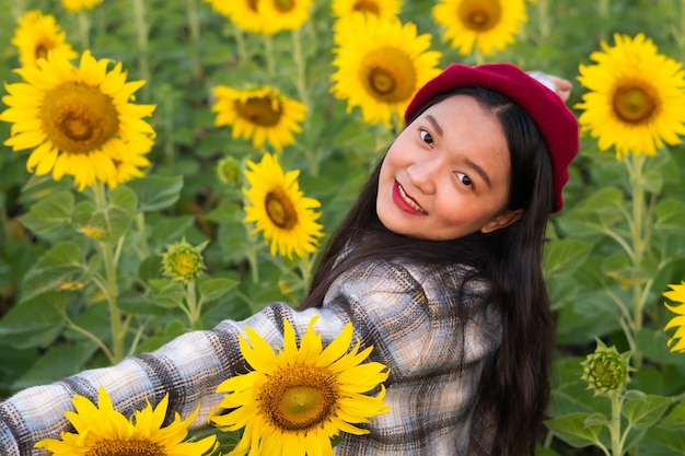 푸른 하늘이 있는 해바라기 밭에서 행복한 어린 소녀