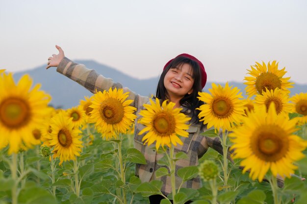 青い空とひまわり畑で幸せな若い女の子