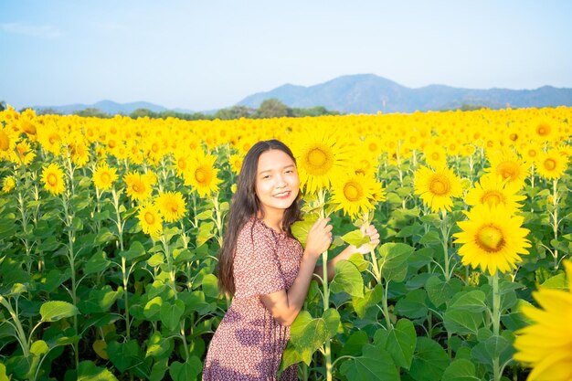 푸른 하늘이 있는 해바라기 밭에서 행복한 어린 소녀