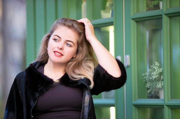 Happy young girl with blond hair near the cafe