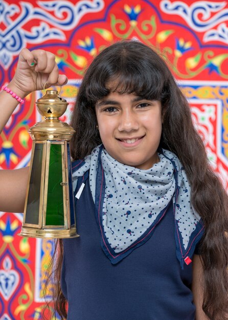 Счастливая молодая девушка с фонарем празднует Рамадан