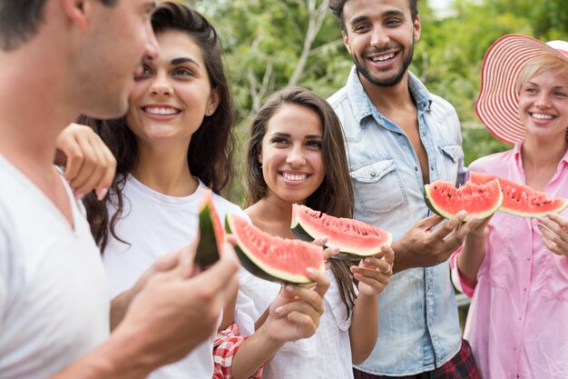 Happy Young Group Of Friends Talking Hold Watermelon Slice 