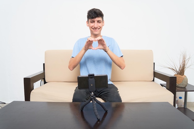 Happy young hispanic deaf man has a video call conversation via\
a smartphone cell phone