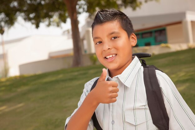 Счастливый латиноамериканский школьник с поднятым пальцем