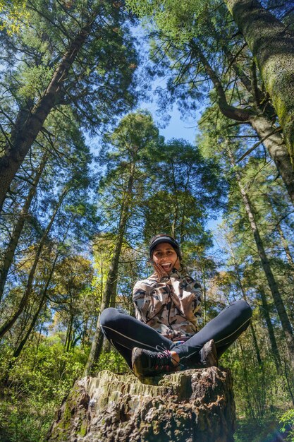 Happy young hispanic woman in summer forest