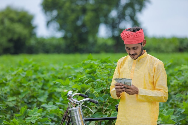 Happy Young Indian farmer counting and showing money