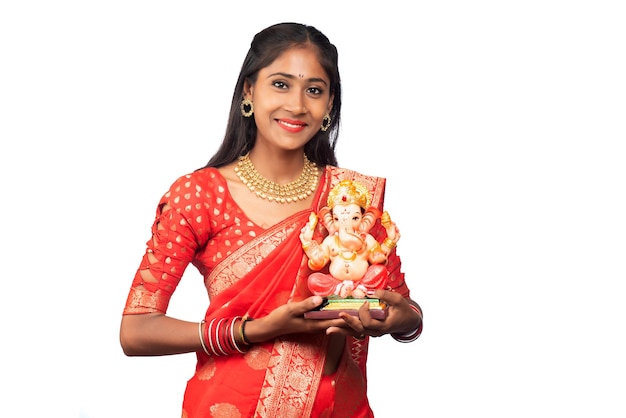 Happy young Indian girl posing with Ganesha statue on the occasion of Ganesh Festival