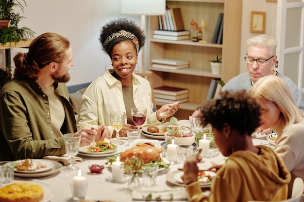 Happy young intercultural couple chatting by served table