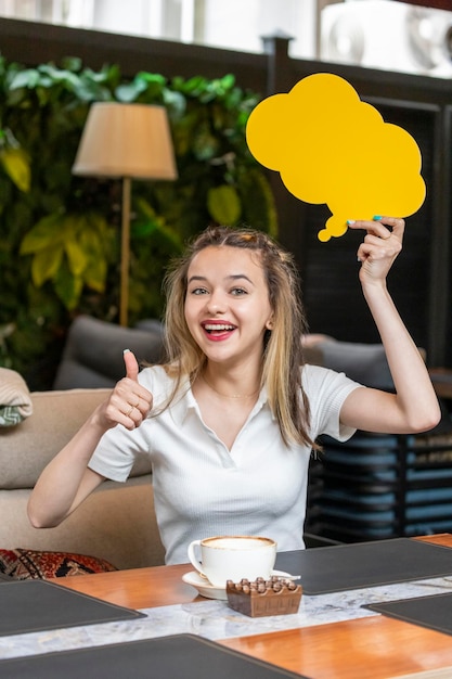 Фото Счастливая юная леди держит доску идей и показывает большой палец вверх