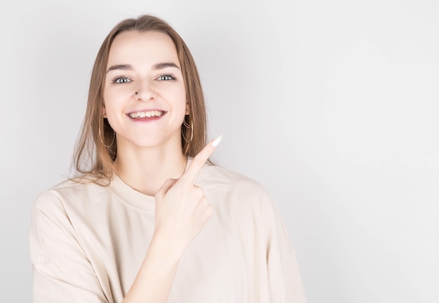 happy young lady pointing at copy space