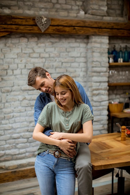Happy young lovely couple in the kitchen hugging each other