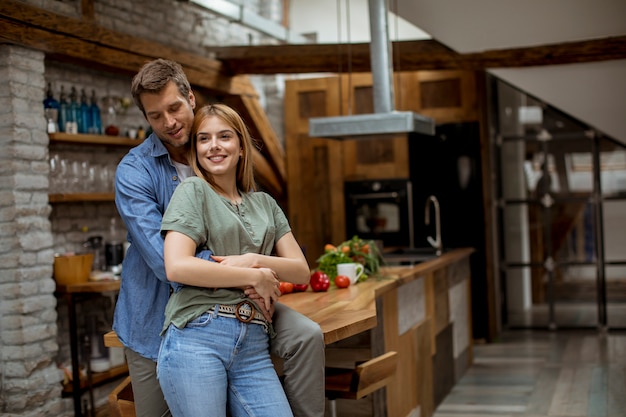 Happy young lovely couple in the kitchen hugging each other