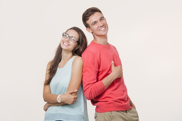 Photo happy young lovely couple standing back to back and smiling