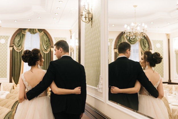 Photo happy young and loving bride and groom stand back and . wedding day