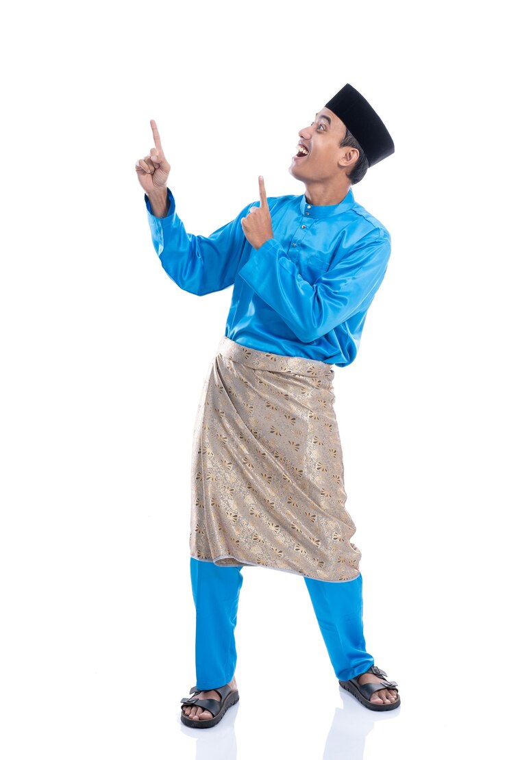 Photo happy young malaysia male looking up pointing to copyspace