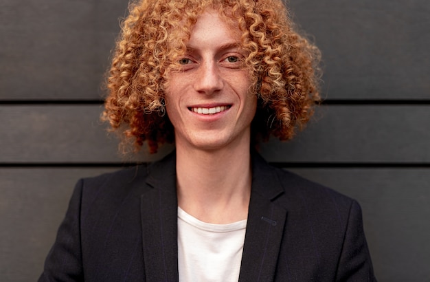 Happy young male with curly ginger hair smiling