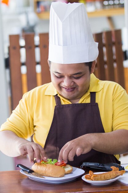 Giovane felice che cucina il suo pasto