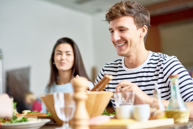 夕食の席で幸せな若い男