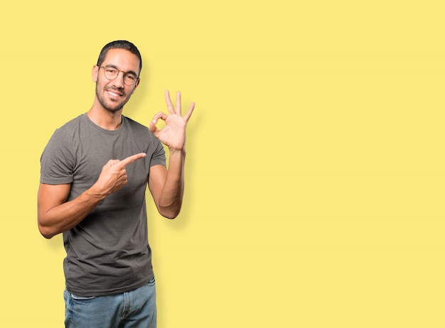 Happy young man doing an all right gesture