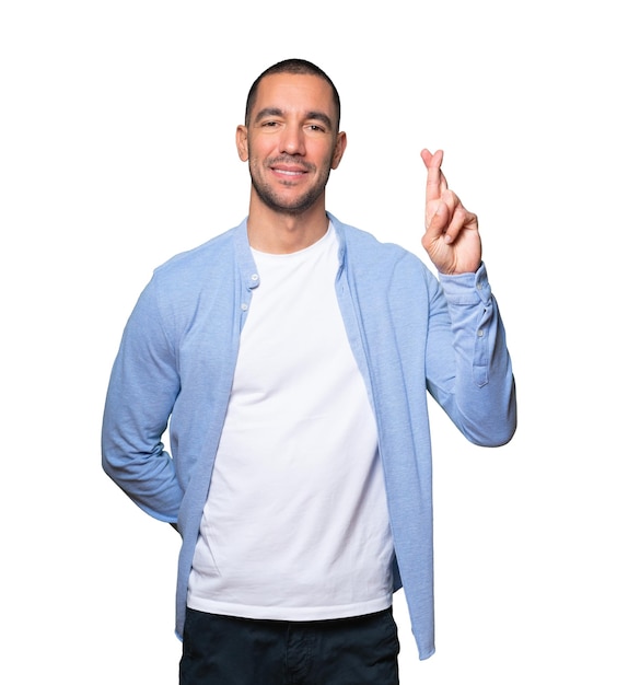 Happy young man doing a crossed fingers gesture