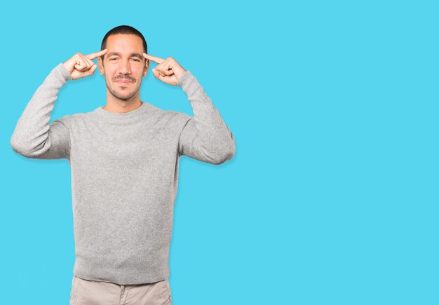 Happy young man doing a gesture of concentration