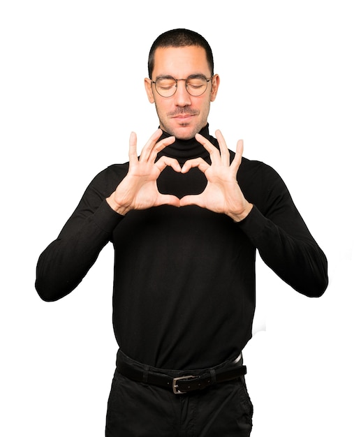 Happy young man doing a gesture of love with his hands