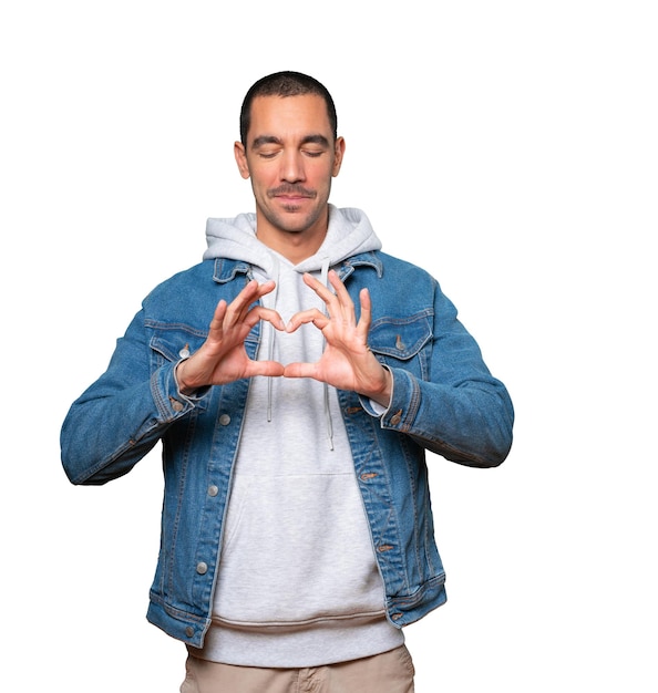 Happy young man doing a gesture of love with his hands