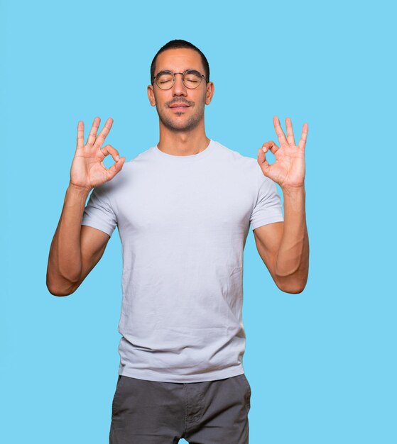 Happy young man doing a gesture of meditation