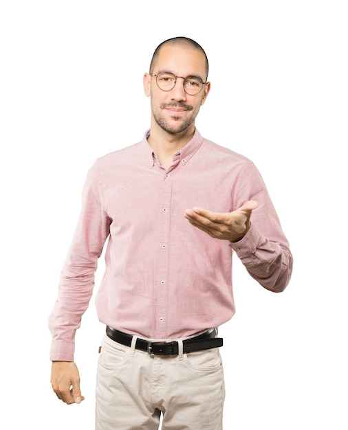 Happy young man doing a gesture of welcome with his hand