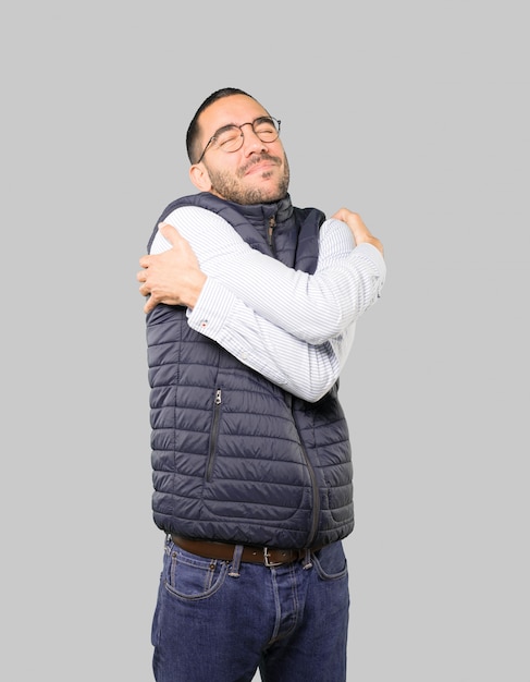 Happy young man doing a hug gesture