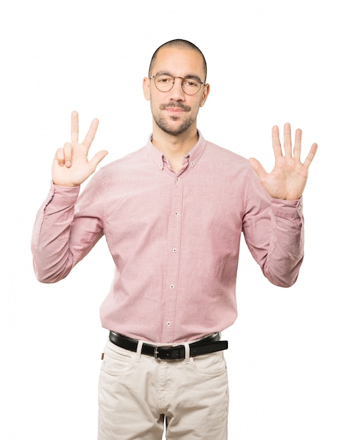 Photo happy young man doing a number eight gesture with his hands