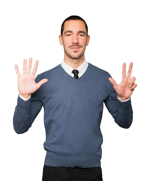 Happy young man doing a number eight gesture with his hands