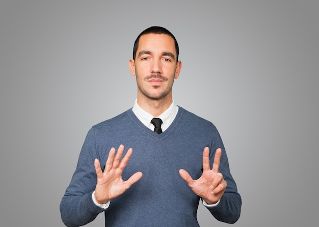 Happy young man doing a number eight gesture with his hands