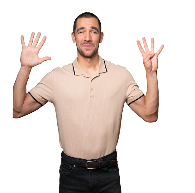 Photo happy young man doing a number nine gesture with his hands