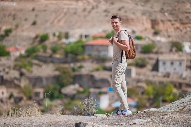 Happy young man hiking on top of hill