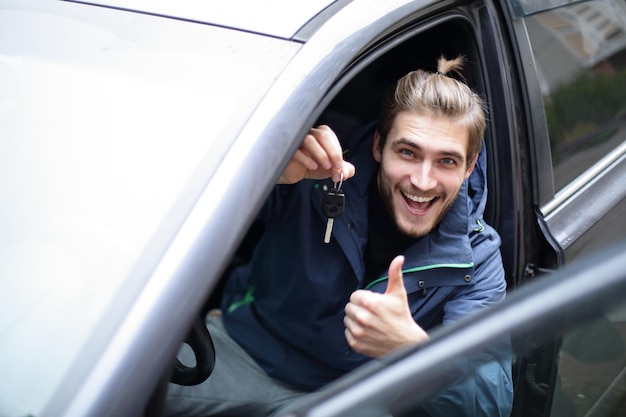 彼の新しい車で幸せな若い男