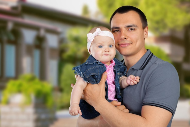 Happy young man holding a baby