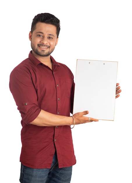 A happy young man holding and displaying a signboard or placard in his hands on a white background