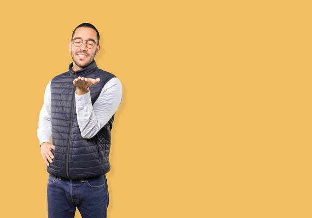 Happy young man holding something with his hand