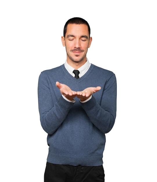 Happy young man holding something with his hand