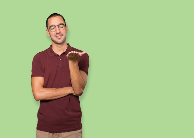 Happy young man holding something with his hand