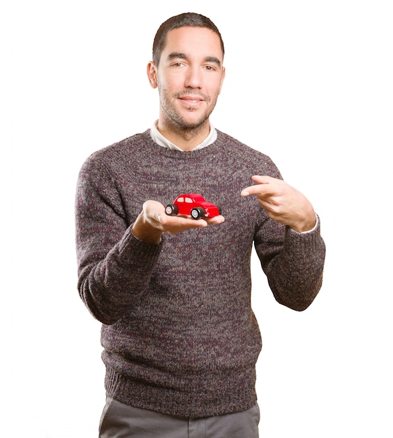 Happy young man holding a toy car