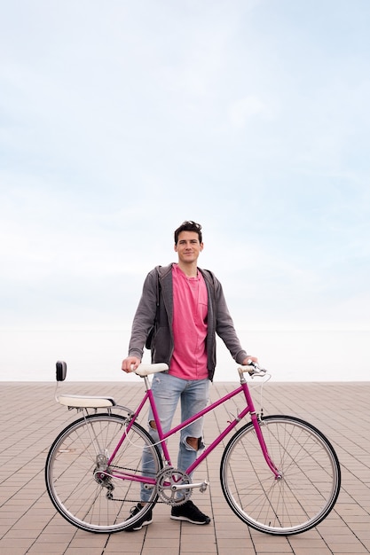 Photo happy young man holding a vintage bicycle