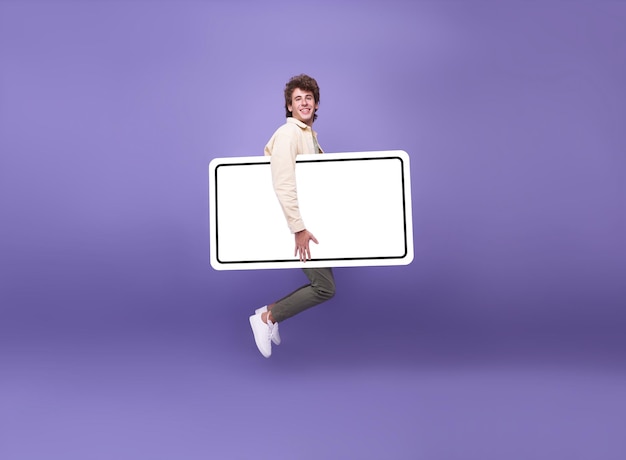 Счастливый молодой человек прыгает в воздух с поднятым вверх, показывая пустой экран смартфона мобильного телефона