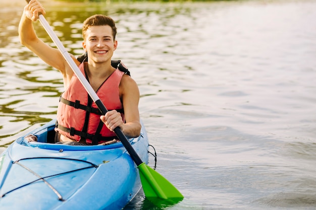 Foto giovane felice che kayaking sul lago